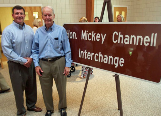 State Rep. Trey Rhodes (L) congratulates his predecessor, Mickey Channell, on the unveiling of a highway sign designating the intersection of I-20 and Ga. 44 as the "Hon. Mickey Channell Interchange."